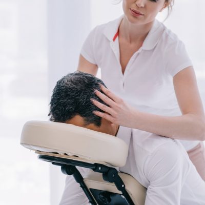 attractive masseuse doing head massage for businessman