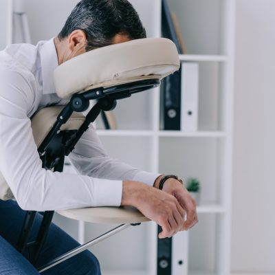 businessman sitting in massage chair at office