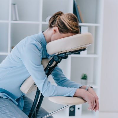 businesswoman sitting on massage chair at office