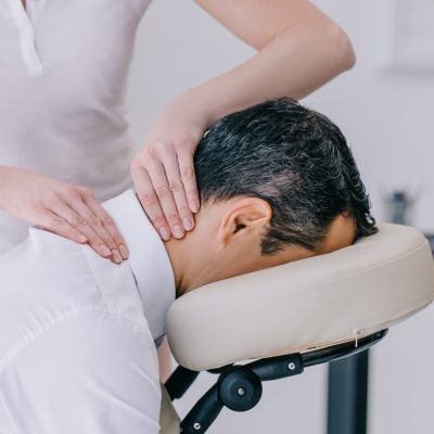 close-up shot of masseuse doing neck massage for businessman