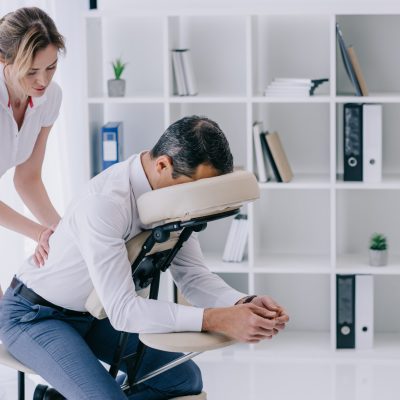 masseuse doing seated massage for businessman