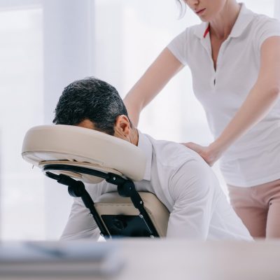 masseuse doing seated massage for businessman