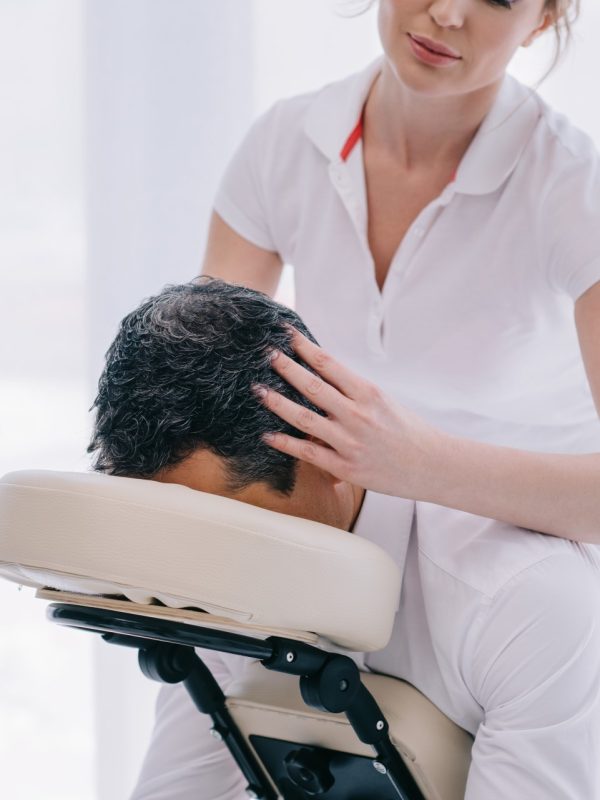 attractive masseuse doing head massage for businessman